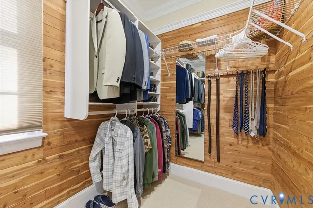 a view of walk in closet with clothes and shoes
