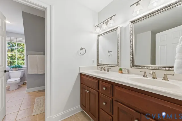 a bathroom with a double vanity sink mirror and toilet