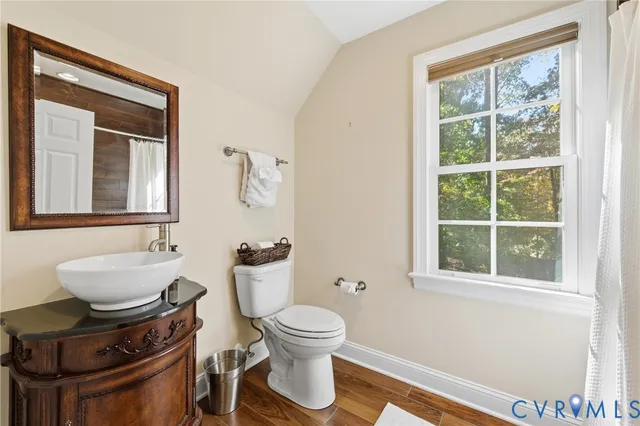 a bathroom with a toilet a sink and a window