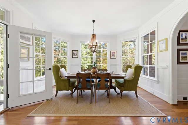 a dining room with furniture a chandelier and wooden floor