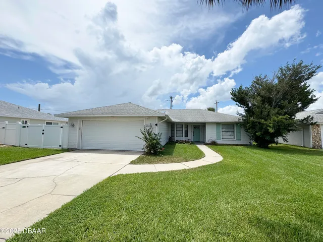 a front view of a house with a yard garage and outdoor seating