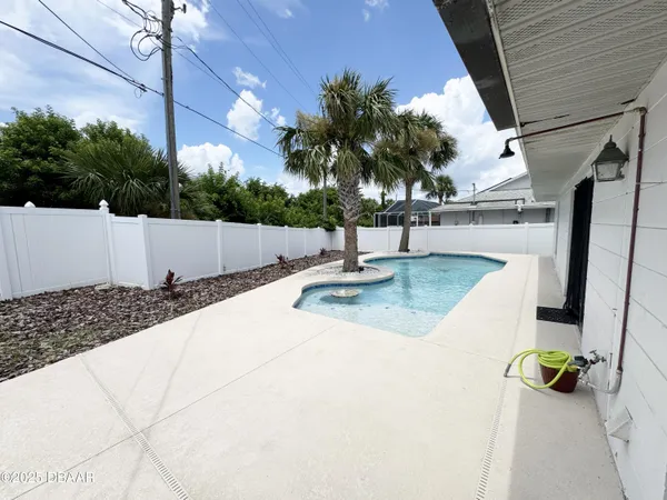 a view of swimming pool with a patio and a garden
