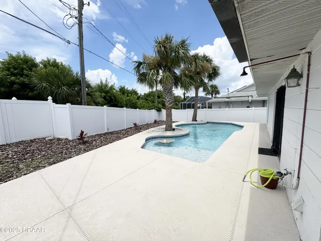 a view of swimming pool with a patio and a garden