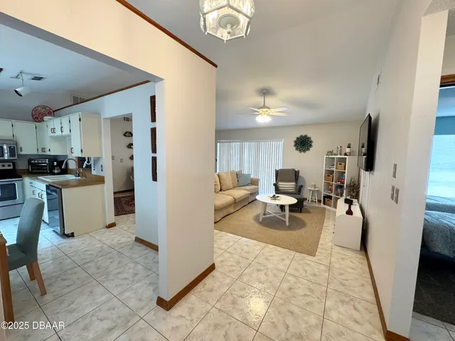 a living room with furniture and a dining table with kitchen view