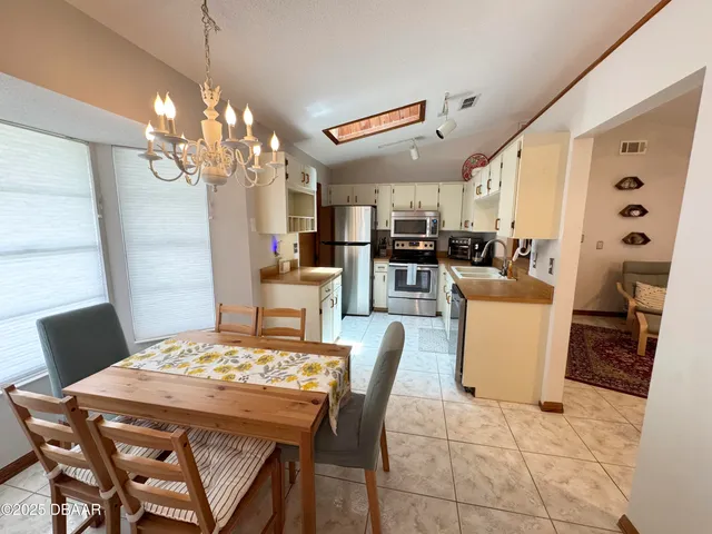 a view of a dining room with furniture and chandelier