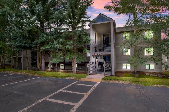 a view of a large building with a big yard and large trees