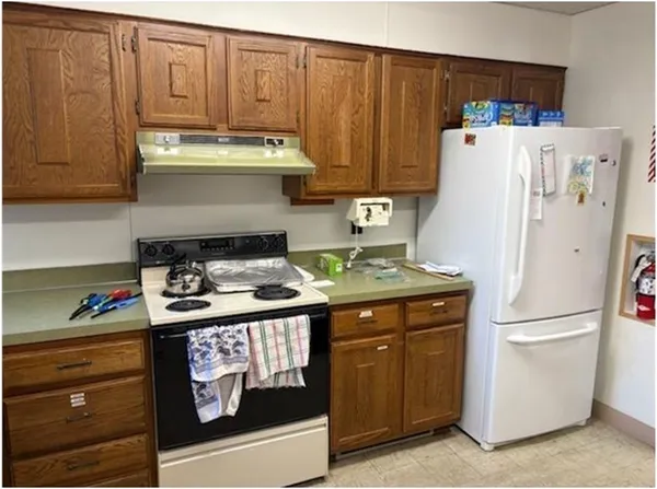 a kitchen with a refrigerator and a stove top oven