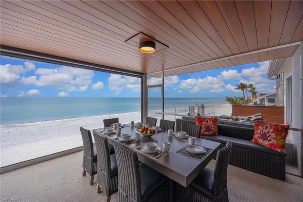 a dining room with furniture and a floor to ceiling window