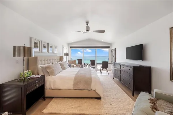 a bedroom with a large bed and a flat tv screen on a dresser