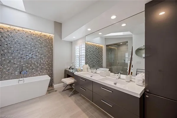 a bathroom with a double vanity sink toilet mirror and bathtub