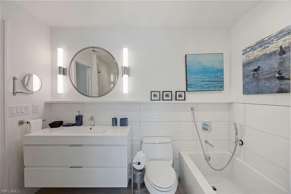 a bathroom with a toilet sink vanity and mirror