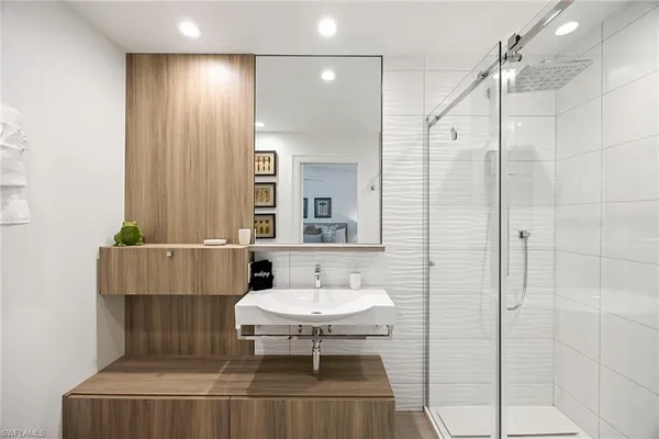 a bathroom with a sink a mirror and a shower