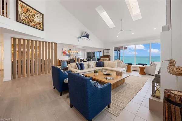 a living room with furniture a large window with kitchen view