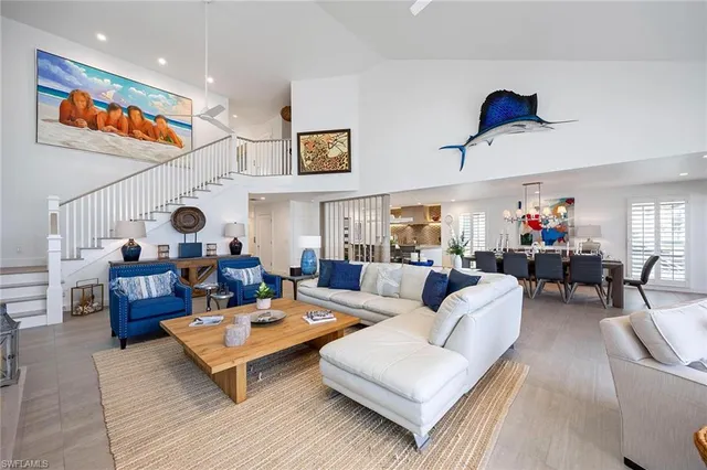 a living room with furniture kitchen view and a large window