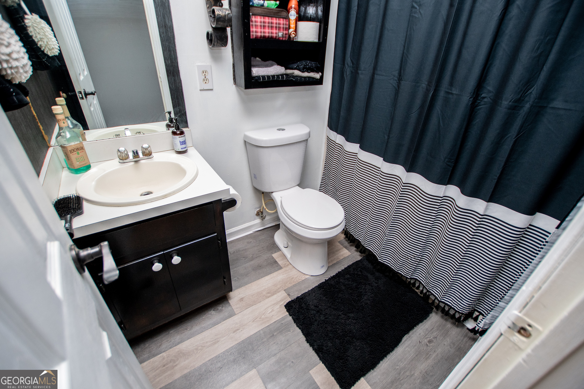 162 Parkway Circle Villa Rica, GA 30180 - Photo 19 of 35 a bathroom with a sink a toilet a mirror and vanity