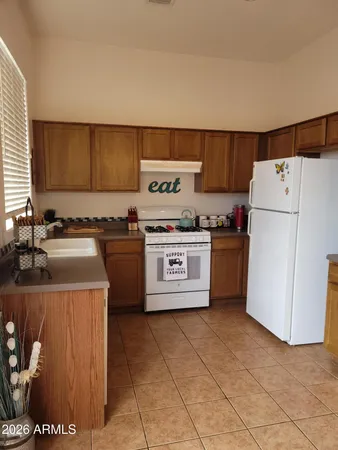 a kitchen with a stove top oven a sink a counter top space and cabinets