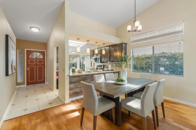 a dining room with furniture a chandelier and wooden floor