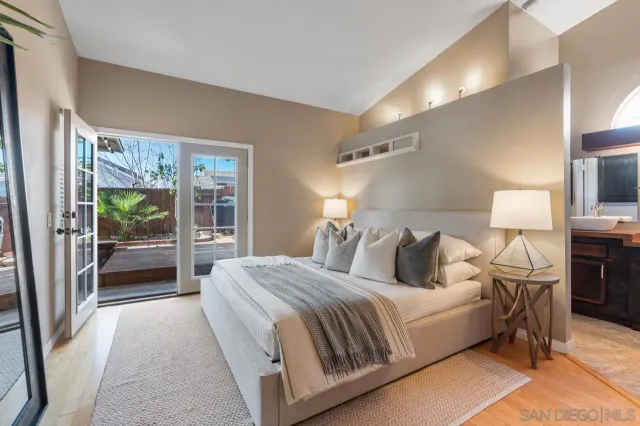 a bedroom with a bed lamp on table and a window