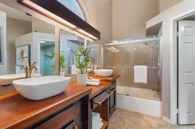 a bathroom with a sink a mirror a bathtub and a shower