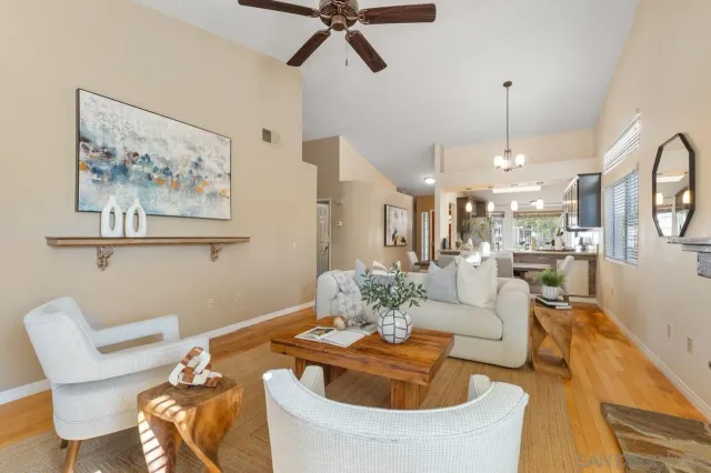 a living room with furniture a chandelier and a painting