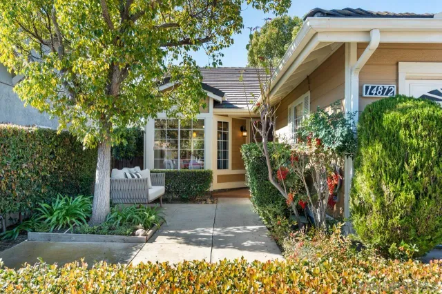 a front view of a house with a yard and fountain in middle of the house