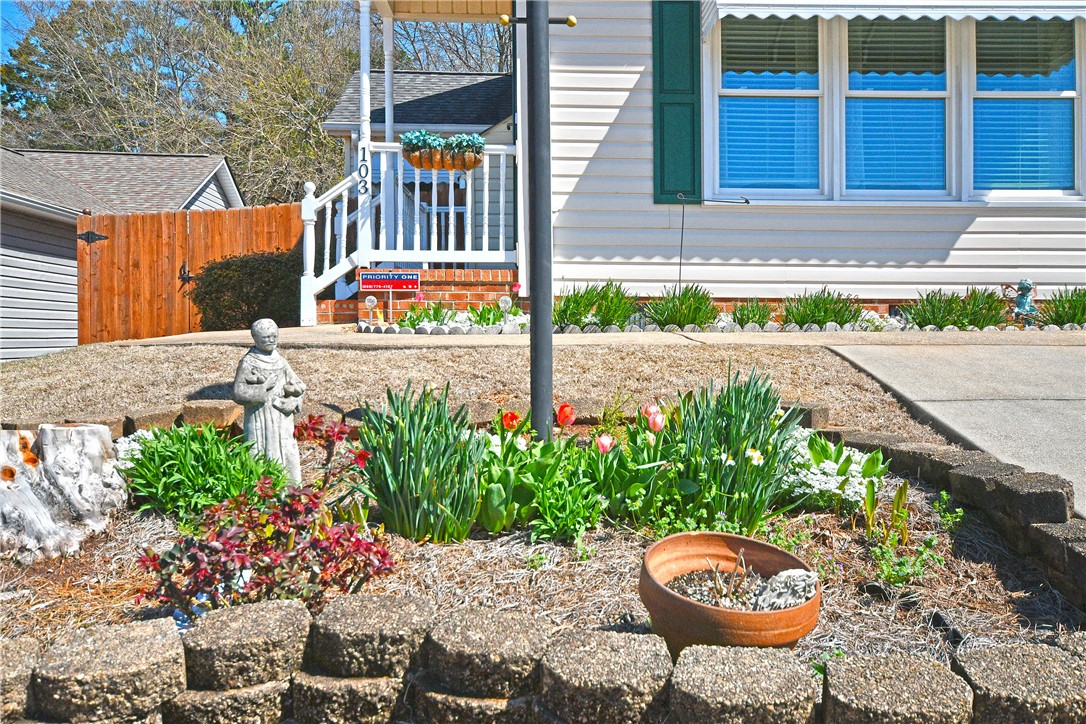 103 Baldwin Place Easley, SC 29642 - Photo 5 of 42 This charming home offers a welcoming facade with blooming garden beds and a private fence.