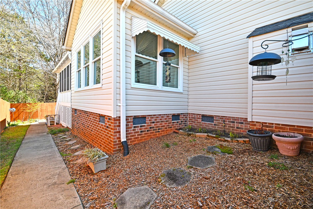 103 Baldwin Place Easley, SC 29642 - Photo 7 of 42 This house features a charming exterior with a blend of brick and siding, complemented by a screened porch.