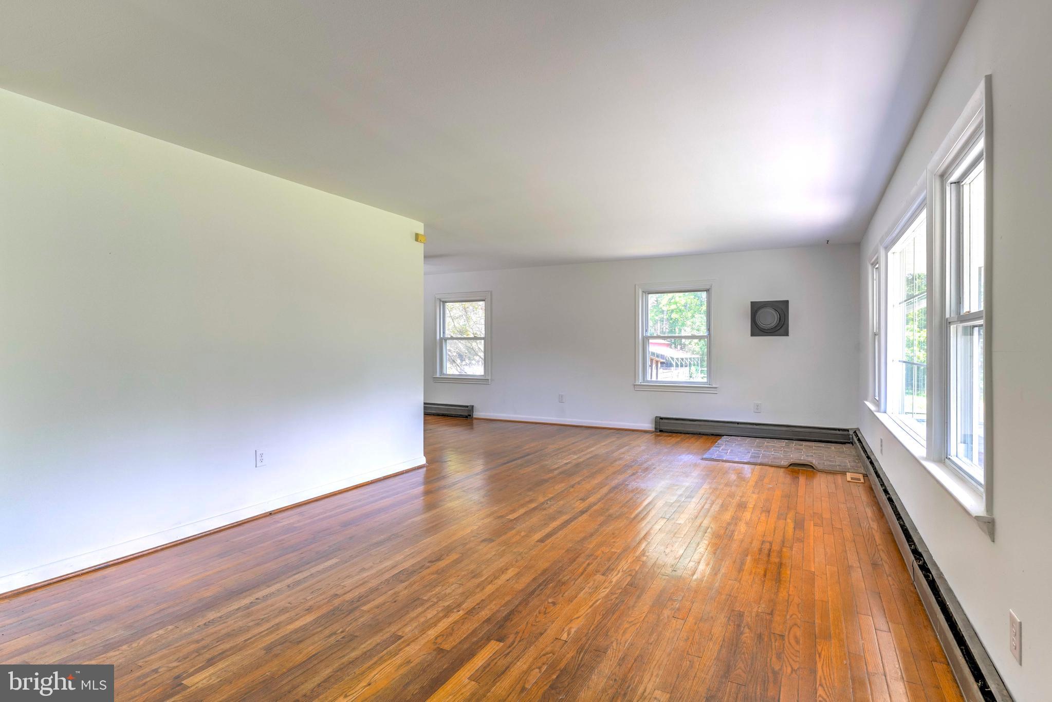 8920 Marshall Corner Road Pomfret, MD 20675 - Photo 8 of 31 an empty room with wooden floor and windows