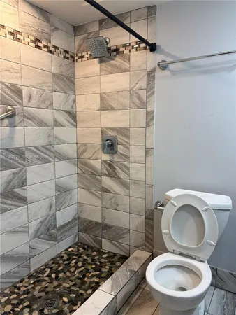 a bathroom with a toilet and a shower