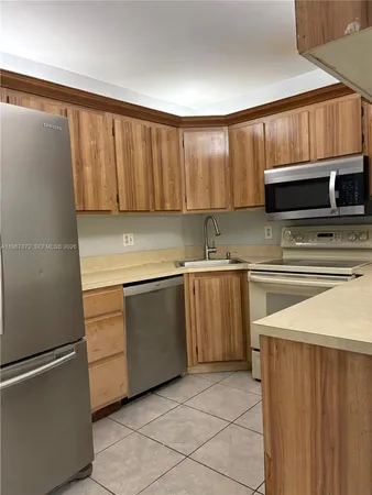 a kitchen with a stove top oven a sink and a microwave