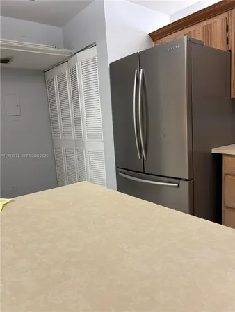 a bedroom with a bed and a refrigerator