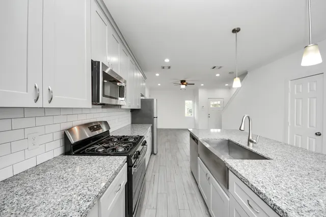 a kitchen with stainless steel appliances granite countertop a sink stove and refrigerator