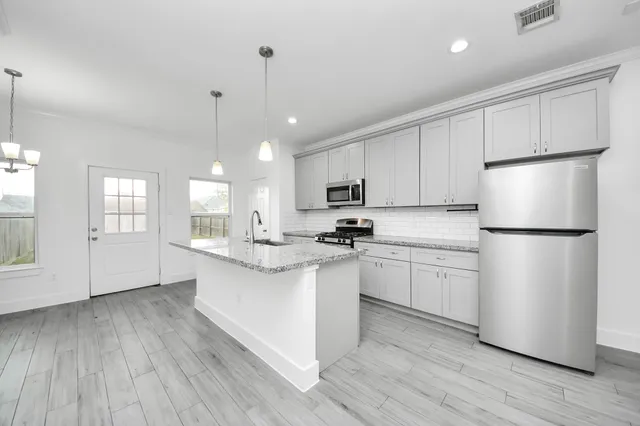 a kitchen with white cabinets and white appliances