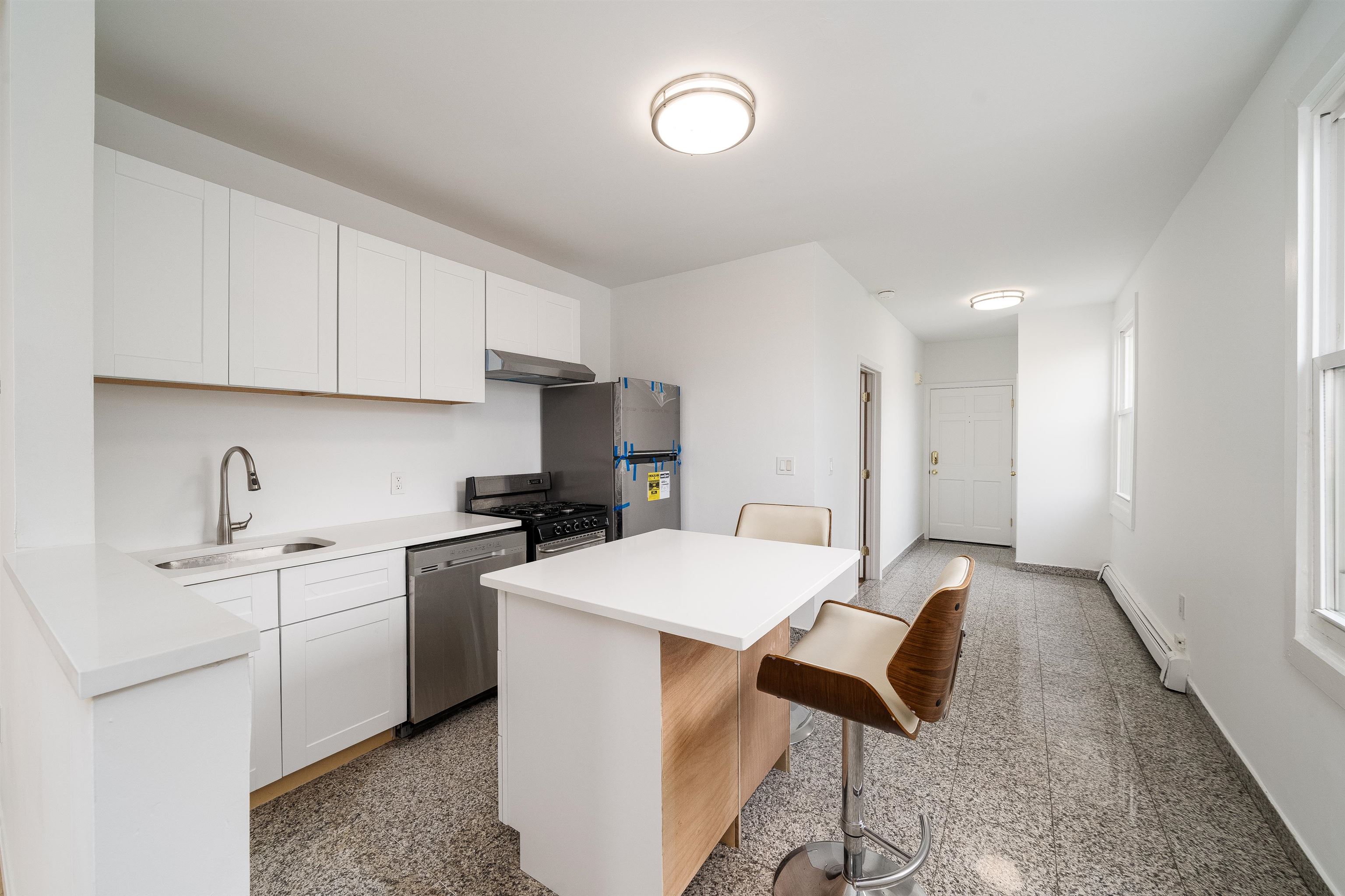 8905 Old River Road, Unit 3 Edgewater, NJ 07047 - Photo 2 of 18 a kitchen with a sink a stove a refrigerator cabinets and a refrigerator