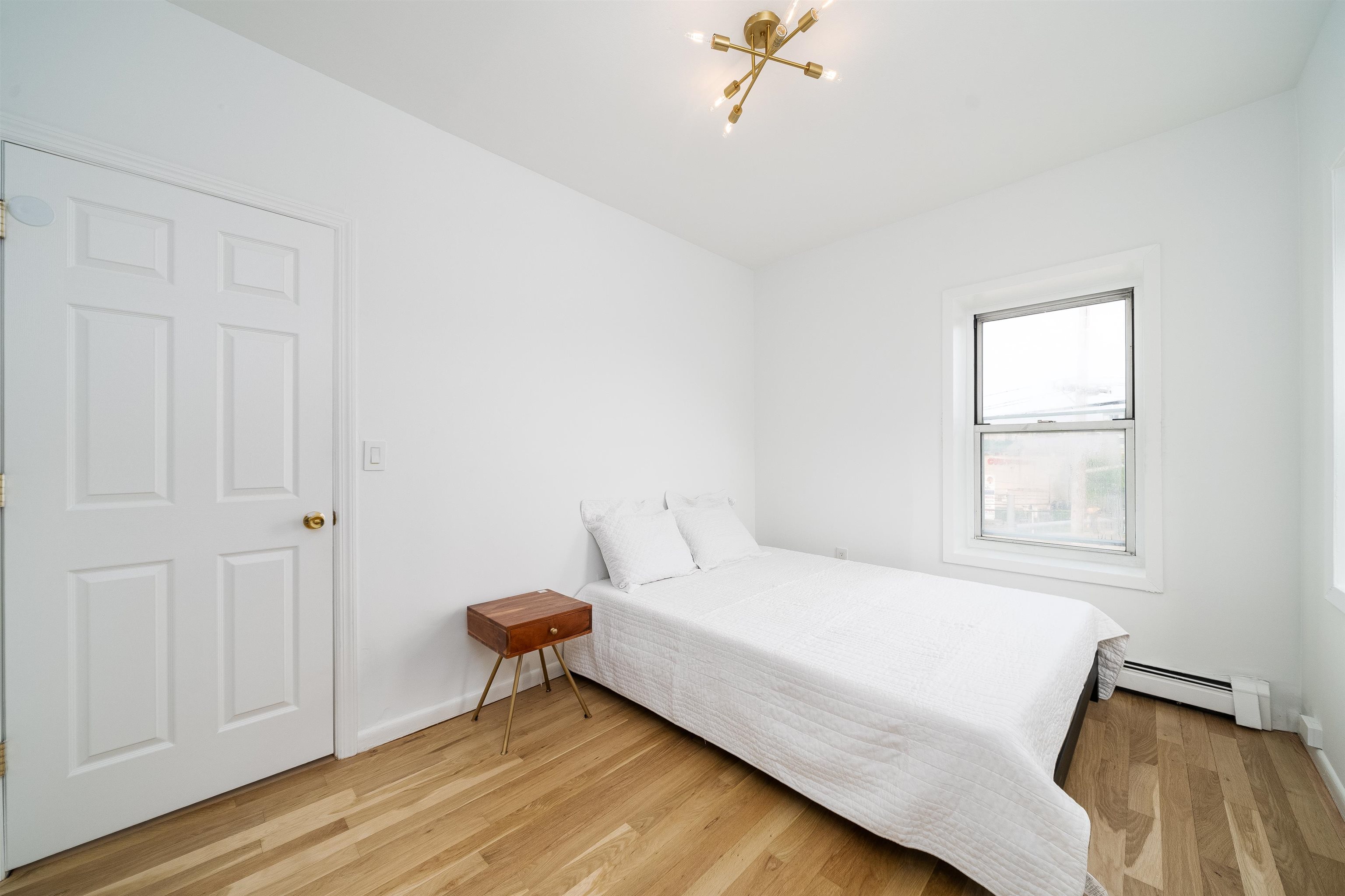 8905 Old River Road, Unit 3 Edgewater, NJ 07047 - Photo 4 of 18 a bedroom with a bed and a chandelier