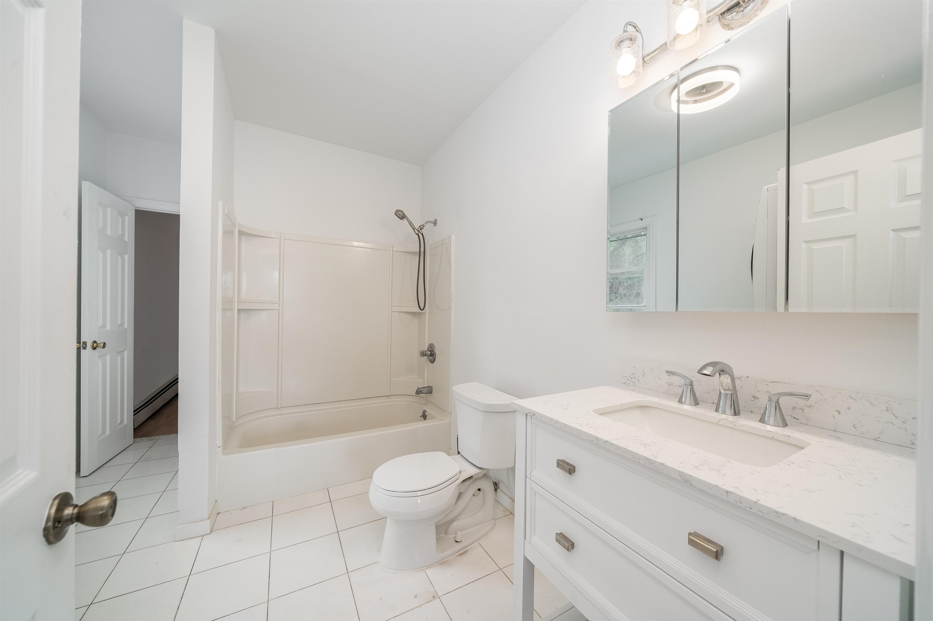 8905 Old River Road, Unit 3 Edgewater, NJ 07047 - Photo 5 of 18 a bathroom with a toilet a sink a mirror and a shower
