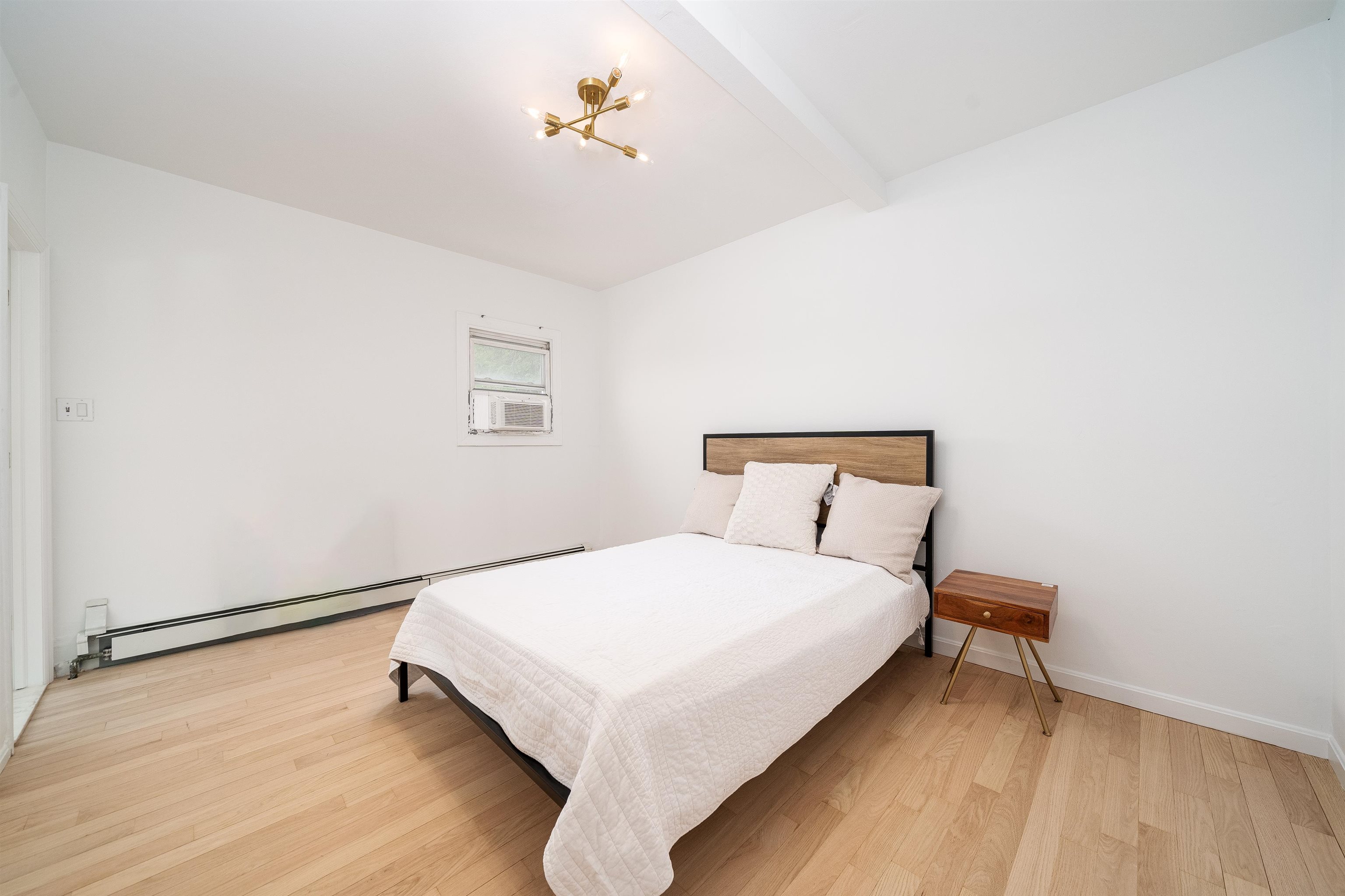 8905 Old River Road, Unit 3 Edgewater, NJ 07047 - Photo 7 of 18 a large bed sitting in a bedroom next to a window with a chandelier