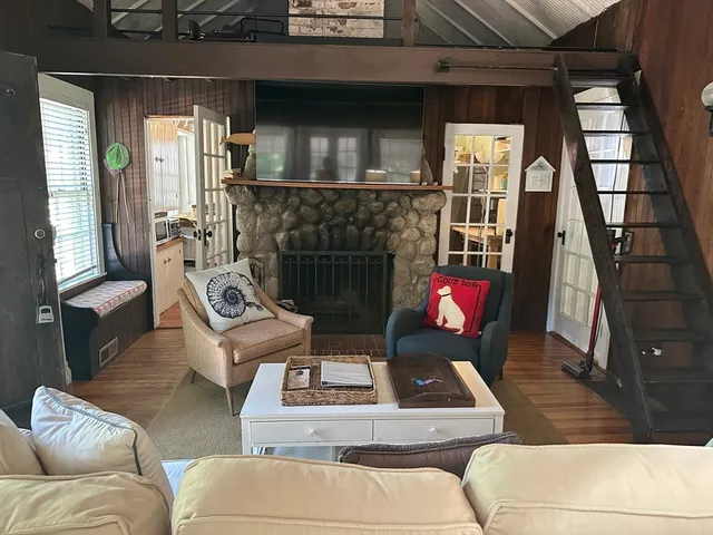 a living room with furniture a flat screen tv and a fireplace