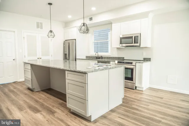 a bathroom with a granite countertop double vanity sink a mirror and a toilet