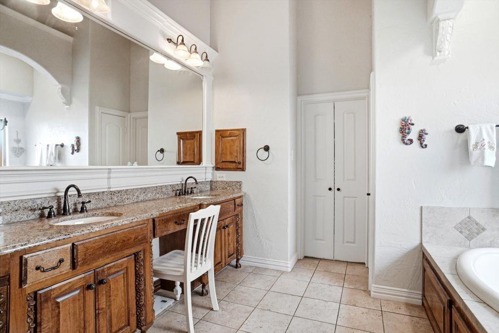 620 Highview Lane Hurst, TX 76054 - Photo 27 of 40 a spacious bathroom with a granite countertop sink a mirror and a bathtub