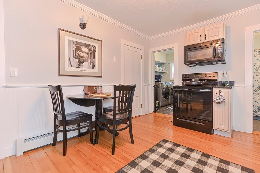 23 Dryden Street Worcester, MA 01605 - Photo 6 of 23 a kitchen with stainless steel appliances granite countertop a stove top oven a sink a dining table and chairs with wooden floor