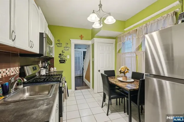 a kitchen with stainless steel appliances granite countertop a sink a stove and a refrigerator