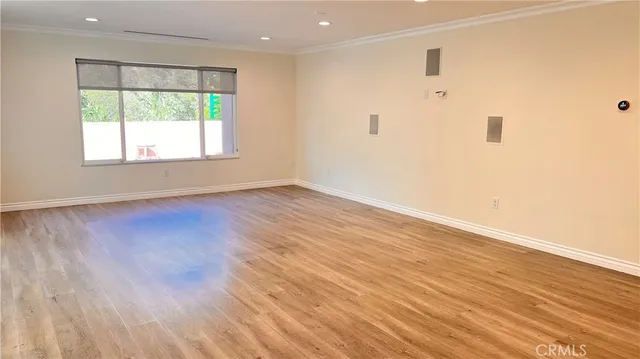 a view of an empty room with wooden floor