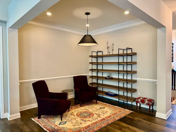 a kitchen with stainless steel appliances granite countertop a stove a refrigerator a kitchen island a dining table and chairs with wooden floor