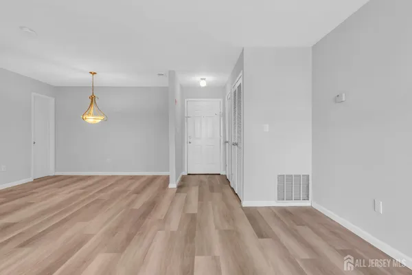 a view of empty room with wooden floor and window