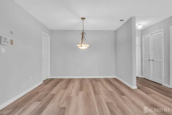 a view of empty room with wooden floor and ceiling fan