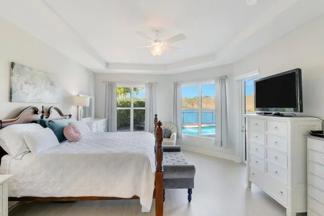 a bedroom with a bed and a flat tv screen on dresser