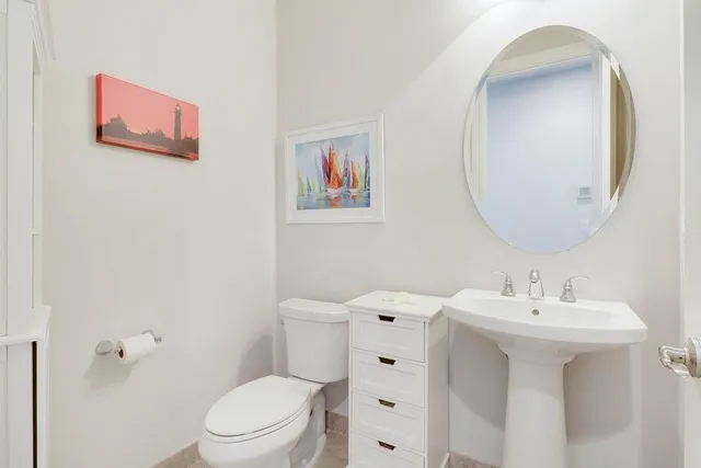 a bathroom with a sink mirror and toilet
