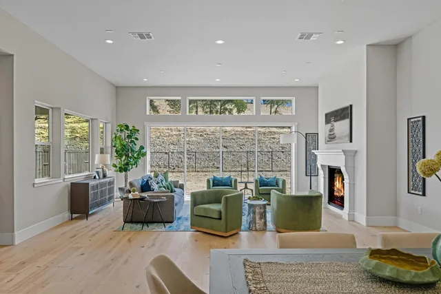 a living room with fireplace furniture and a large window