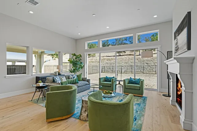 a living room with furniture a fireplace and a floor to ceiling window
